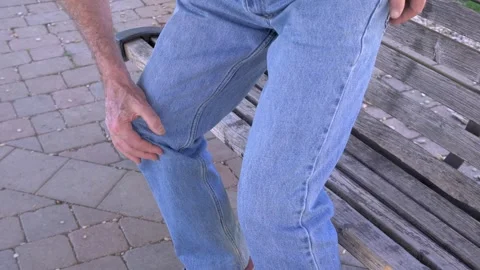 Elderly man standing from bench feels sharp knee pain suddenly 스톡 동영상 333194835