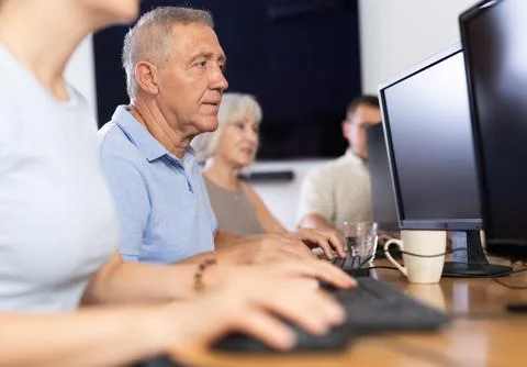 Elderly man studying at computer course in group Stock Photos