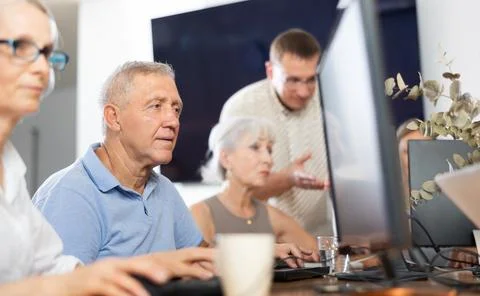 Elderly man studying at computer course in group Stock Photos