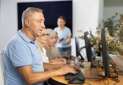 Elderly man studying at computer course in group Stock Photos