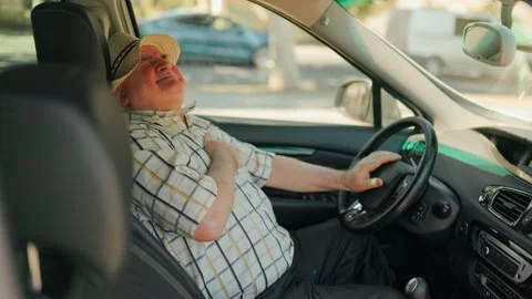 Elderly man suffering severe chest pain while driving a car during sunny day. Stock Footage 343264145