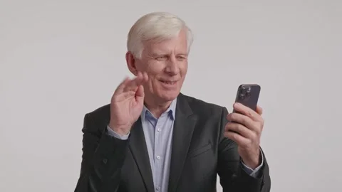 Elderly man in suit using cell phone with microphone for event communication Stock Footage 266921770