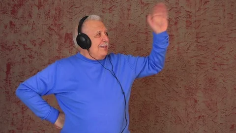 Elderly man in sweatshirt waves left hand and shakes body 動画素材 108605065