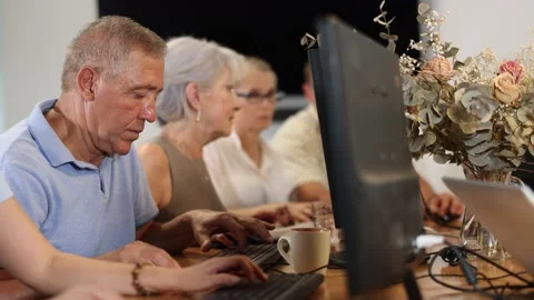 Elderly man taking computer lessons with group of elderly people in a nursing Stock Footage 320929154