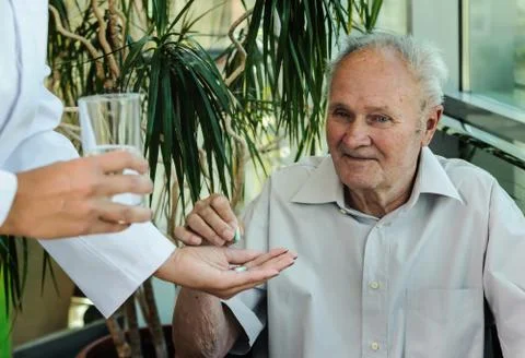 Elderly man is taking medication. Stock Photos