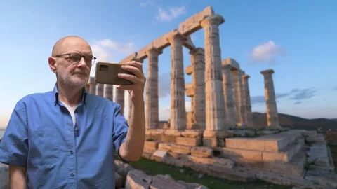 Elderly Man Taking Selfie At Ancient Greek Ruins During Sunset For Travel Stock Footage 329906213