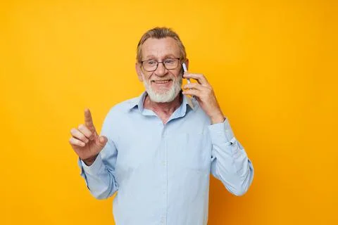 Elderly man talking on the phone posing close-up cropped view Stock Photos