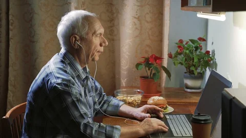 An elderly man talking on a video connection using a laptop showing a thumb up Stock Footage 128224065