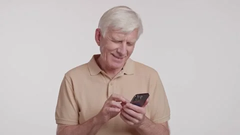 The elderly man taps on his cell phone screen with his thumb Stock Footage 266922252