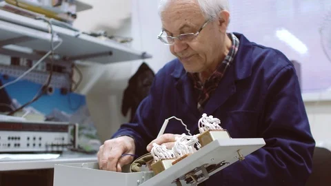 Elderly man testing electrical appliance Stock Footage 104286350