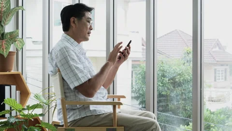 Elderly man think and using mobile phone, sitting on chair. Lifestyle of reti Video stock 138307569