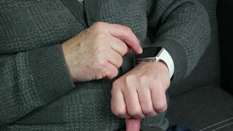 Elderly man uses smart watch in the room Stock Footage 234294071