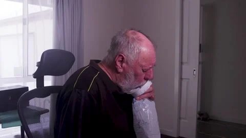 Elderly Man Using Breathing Device in a Calm Indoor Setting Stockbeeldmateriaal 332685929