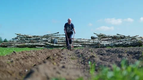 Elderly Man Using Manual Tool in Field – Symbol of War and Agricultural Crisis 動画素材 318068271