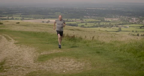 Elderly man using phone while jogging in field Stock-Footage 59899890