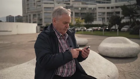 Elderly man using smartphone in park Video stock 275149359