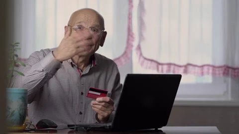 Elderly man verifies payment card details and rejoices Stock Footage 247019448