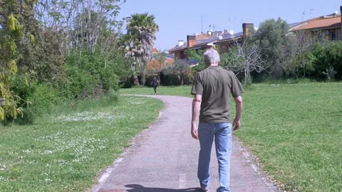 Elderly man walking alone through park in calm solitude 스톡 동영상 333194687