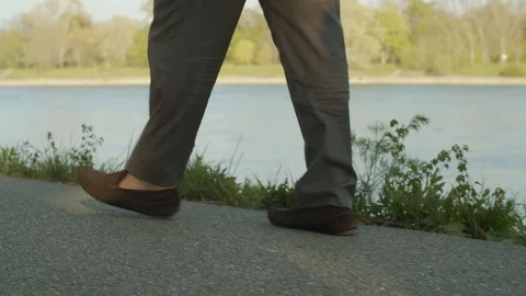Elderly man walking next to a river in slow motion Vídeos de archivo 108371477
