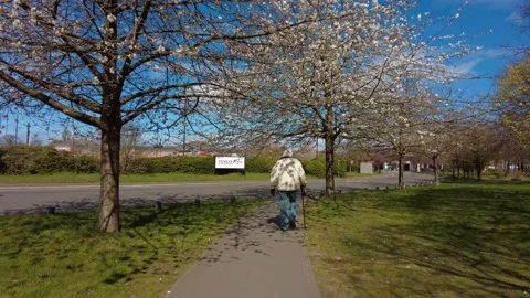 An elderly man with walking stick going towards Tesco Superstore Stock Footage 153289084