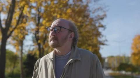 Elderly man wearing glasses and a scarf on a calm fall day outdoors Stock Footage 297253653