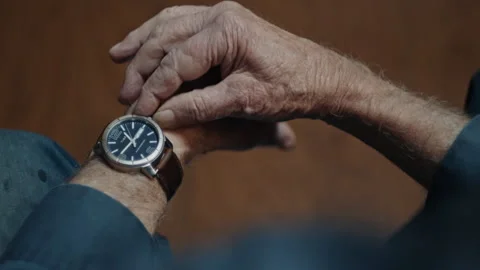 Elderly man with a wrist watch checking the time 스톡 동영상 334100590