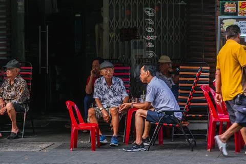 Elderly Men Conversing at a Sidewalk Cafe in Vietnam Stock-Fotos