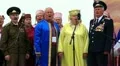 Elderly men in military uniform and women in color costume sing a song HD Footage