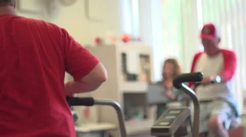 Elderly men work out while nurse stands by Stock Footage 10716847