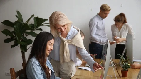 Elderly mentors helping interns with corporate program moving camera slider Stock Footage 107494792