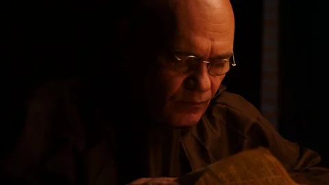 An elderly monk leafs through an ancient book 動画素材 94415163