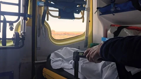Elderly patient's hand resting inside a moving ambulance Stock Footage 337187508