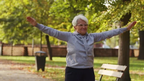 Elderly pensioner grey-haired lady exercising outdoors, keeping her body healthy Stock Footage