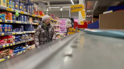 Elderly pensioner woman choosing products. Grocery store, price increase Stock Footage