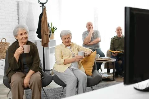 Elderly people watching TV in geriatric hospice. Senior people care Stock Photos