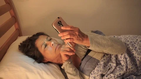 Elderly person in bedtime using mobile. Stock Footage 102558479