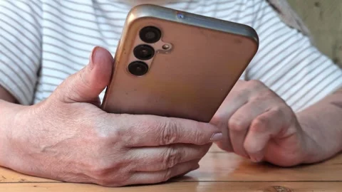 Elderly person uses smartphone at table Stock Footage 341772266