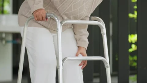 Elderly person walks with walker support Vídeo Stock 345216100