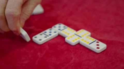 Elderly person's hand carefully placing a domino tile during a game Stock Footage 337694808