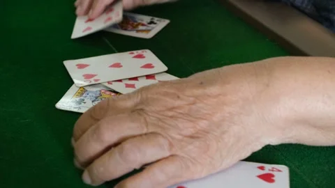 An elderly person's wrinkled hands, aged around 80,playing a card game Stock Footage 290476254