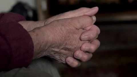 Elderly person's wrinkled hands clasped together Vidéo 344532856