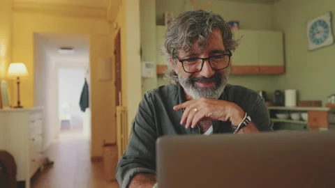 Elderly positive man typing working on laptop sitting in home kitchen Stock Footage 229506080