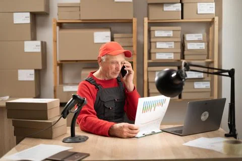 Elderly postal worker calling client about parcel delivery 스톡 사진