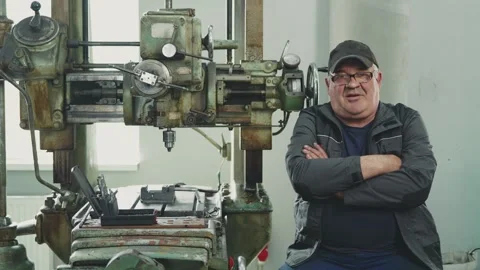 Elderly professional locksmith with extensive experience at a lathe at a mature Stock Footage 281582636