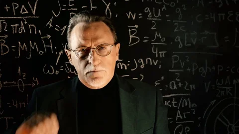 Elderly professor giving a lecture, mathematical formula on blackboard Stock Footage 129043204