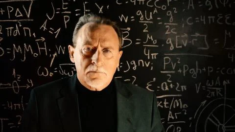 Elderly professor giving a lecture, mathematical formula on blackboard.  Stock Photos