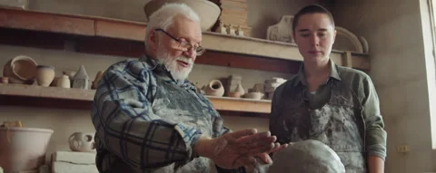 Elderly Sculptor Teaching Young Apprentice in Pottery Studio Video stock 167270977
