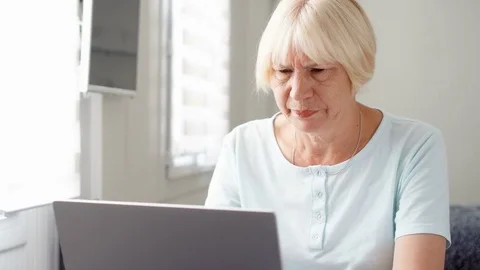 Elderly senior woman receiving very bad news on his laptop computer screen and Stock Footage