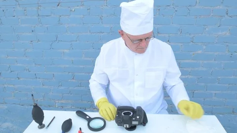 Elderly solid person in white dressing gown, cap, medical mask, glasses clean Stock Footage 93429024