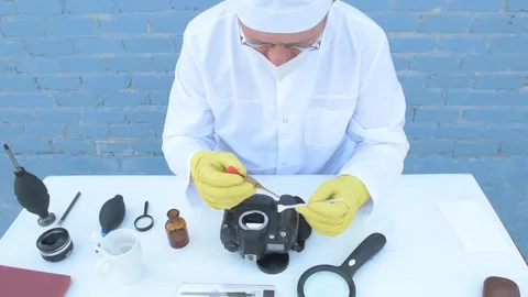 Elderly solid person in white dressing gown, cap, medical mask, glasses clean Stock Footage 93429151